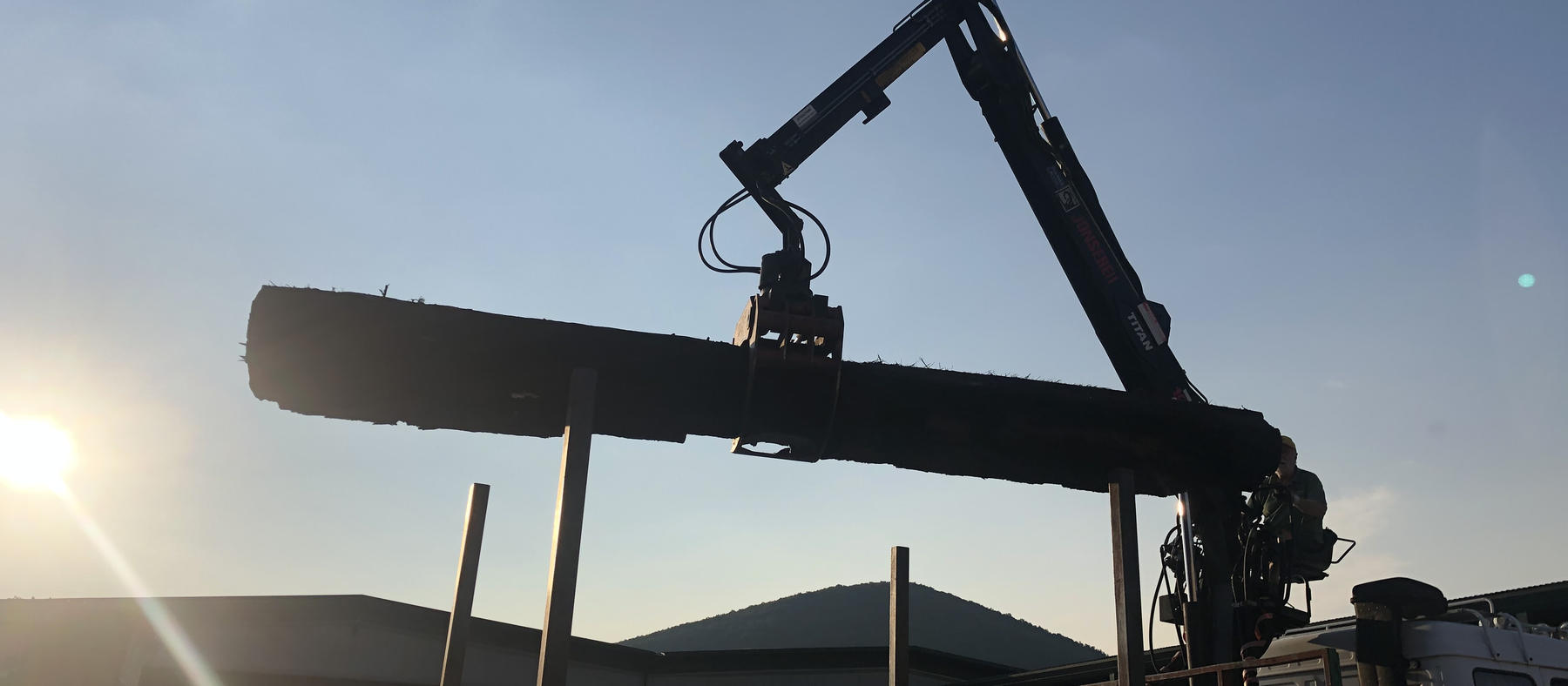 Scarico di un tronco al tramonto